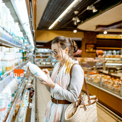 Comprador mirando leche y productos lácteos en la tienda