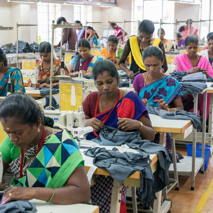 Mujeres en máquinas de coser en una fábrica Fair Trade Certified - Connoisseur Fashions