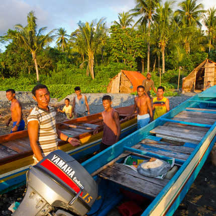 grupo de pescadores en la costa junto a un barco en Indonesia
