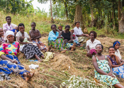 A group of women from the Mpanga Growers Tea Factory in Uganda gathered outside in their community.