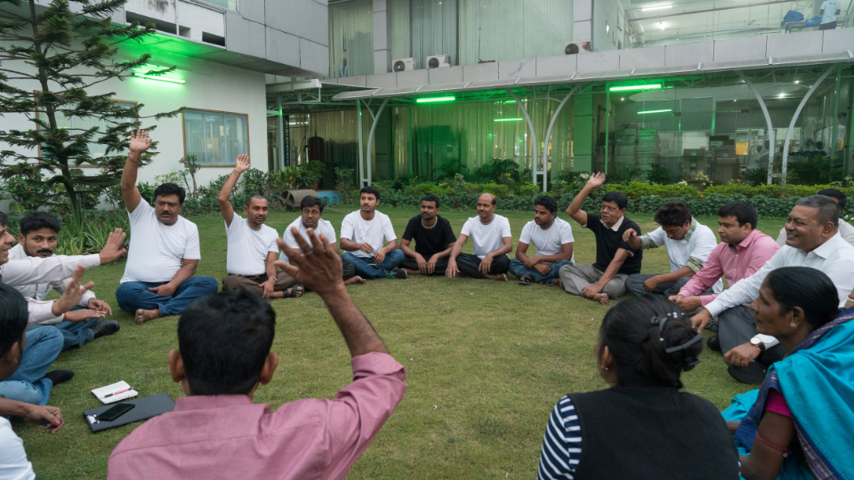 Workers and management have a Fair Trade committee meeting outdoors in the courtyard garden at the Rajlakshmi Cotton Mills in Howrah.